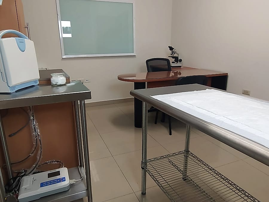 Consultorio con mesa de exploración y microscopio